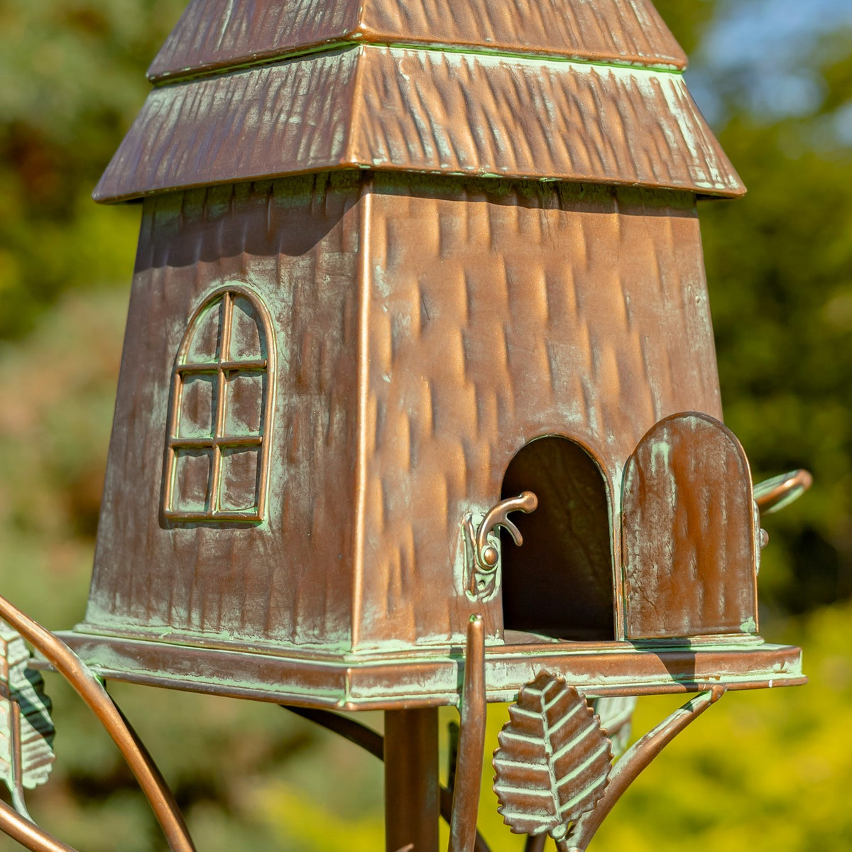 Close view of the copper-finish birdhouse entrance and raised roof details