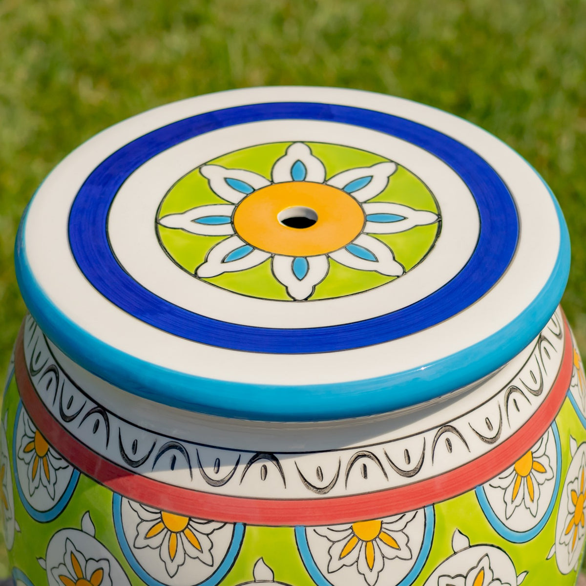 Overhead detail of the stool's blue-edged seat with a floral design and a small central opening.