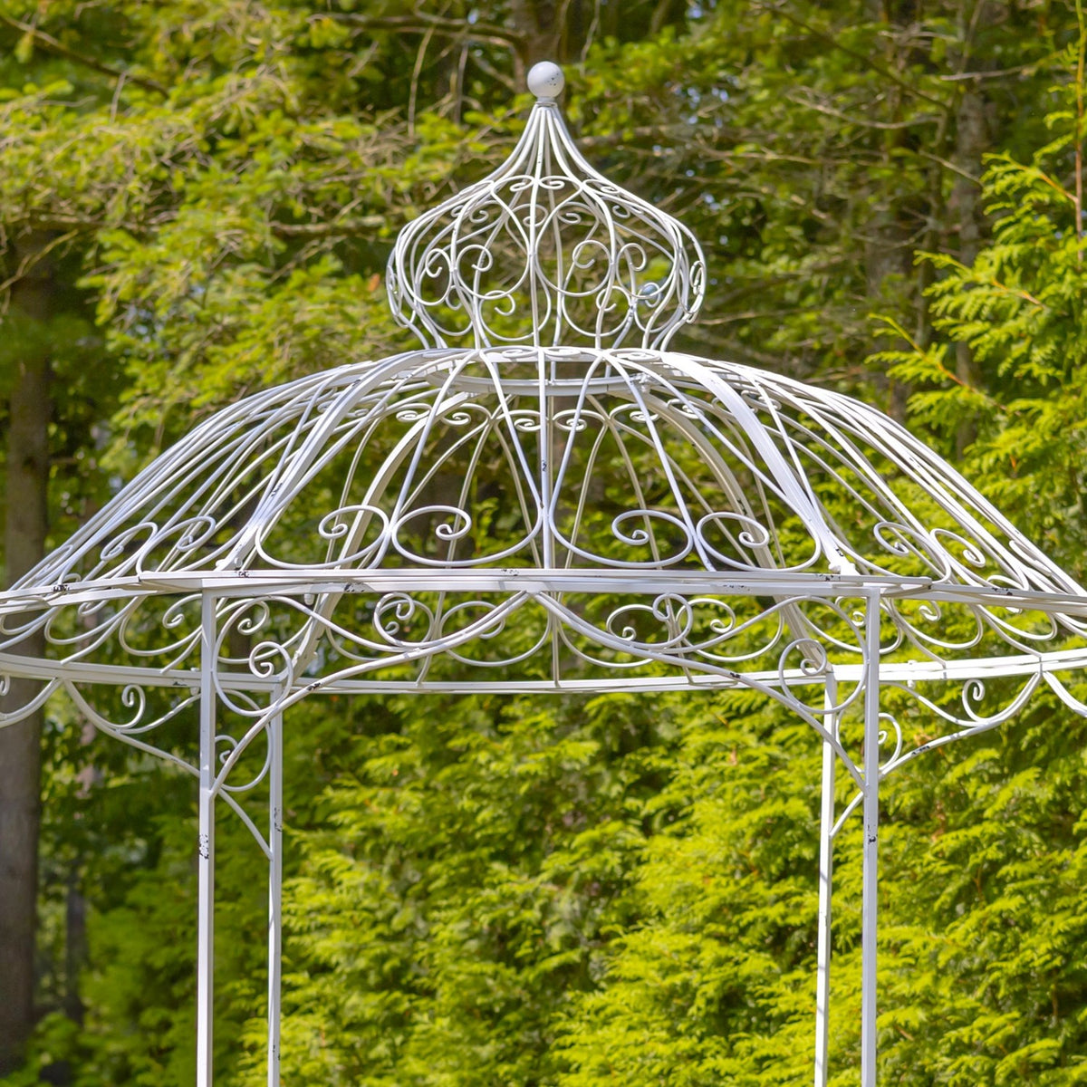 Close view of the white gazebo's ornate domed roof and scrollwork