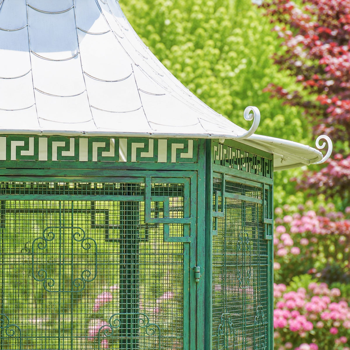 Close view of the gazebo’s green lattice panels, geometric trim, and curled roof-edge ornament.