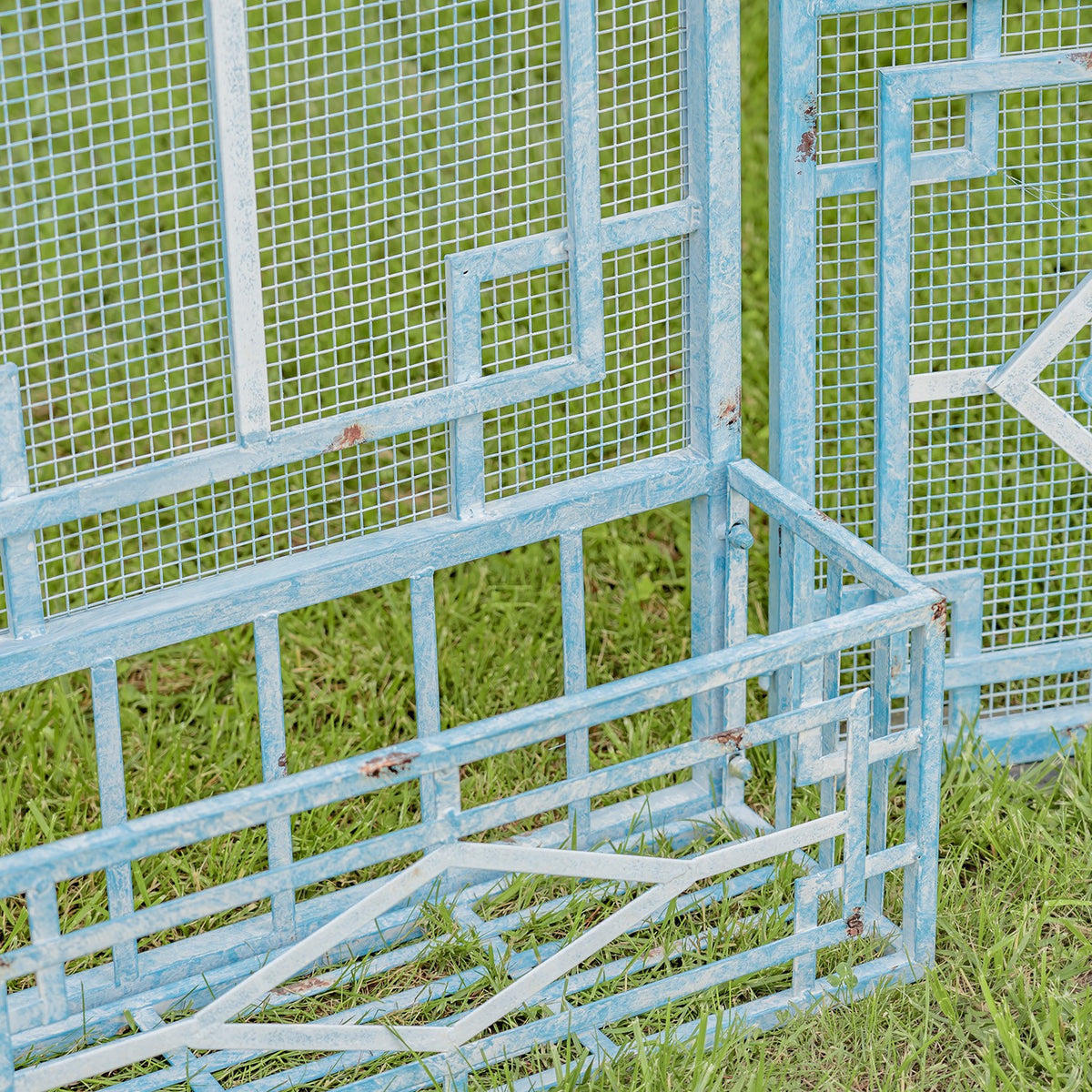 Close-up of an empty rectangular planter integrated into the gate's blue metal latticework.