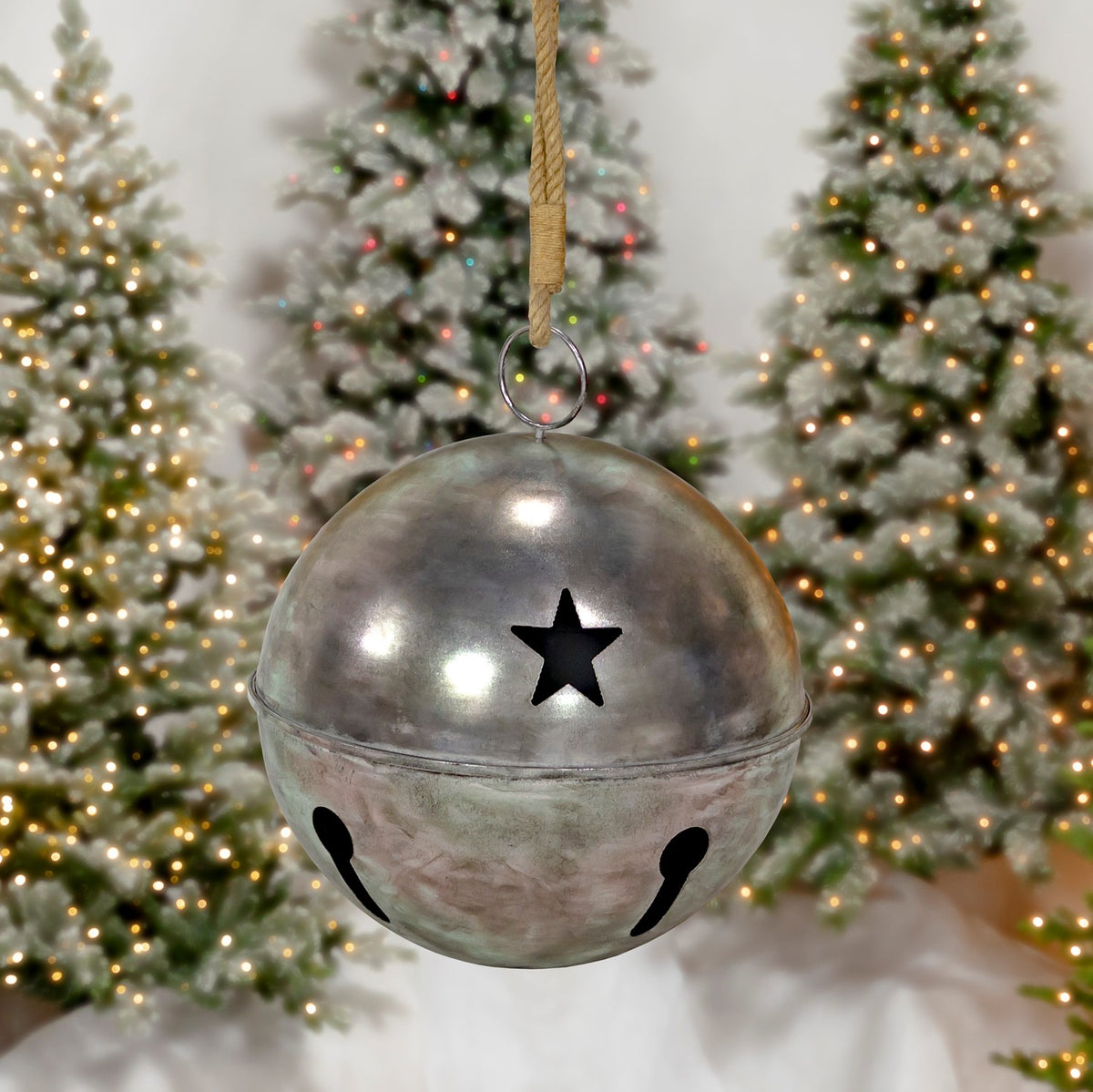 A smaller silver bell hangs from a cord, showing a star cutout and two dark openings.
