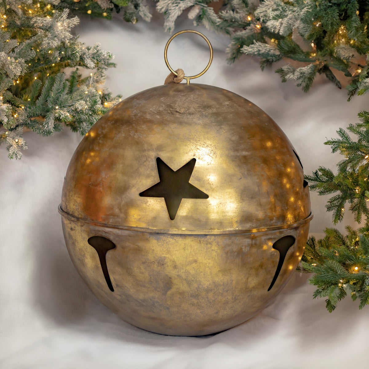Large gold bell hanging by a loop, with a star cutout and openings around its lower half.