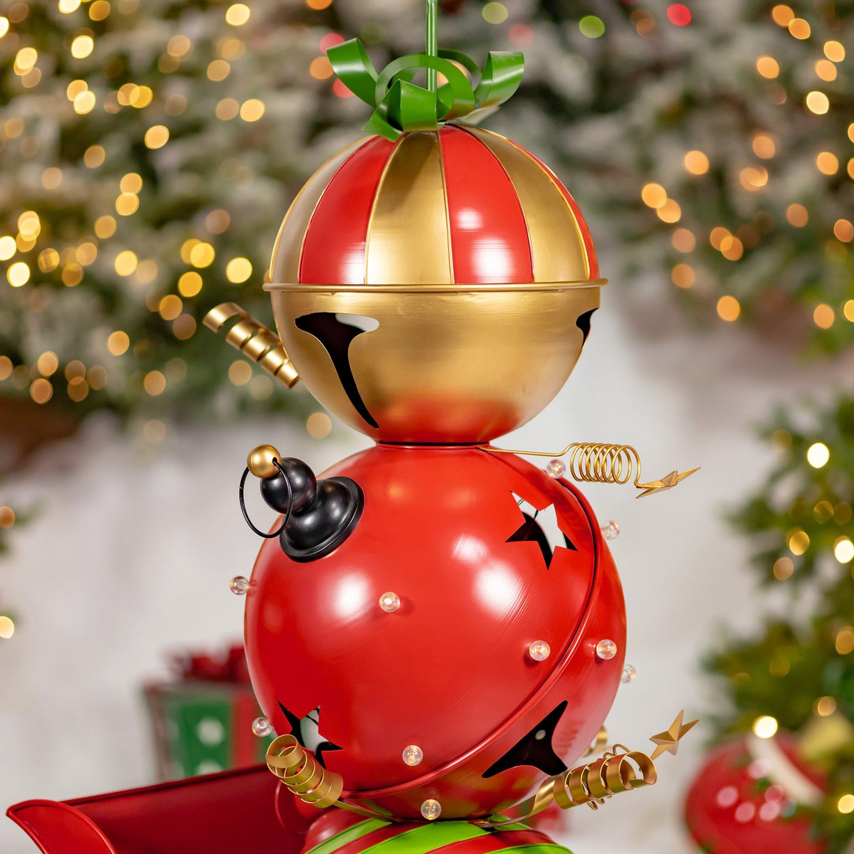 Close-up of the stacked bells, showing the gold-and-red top bell, green bow, and decorative coils.