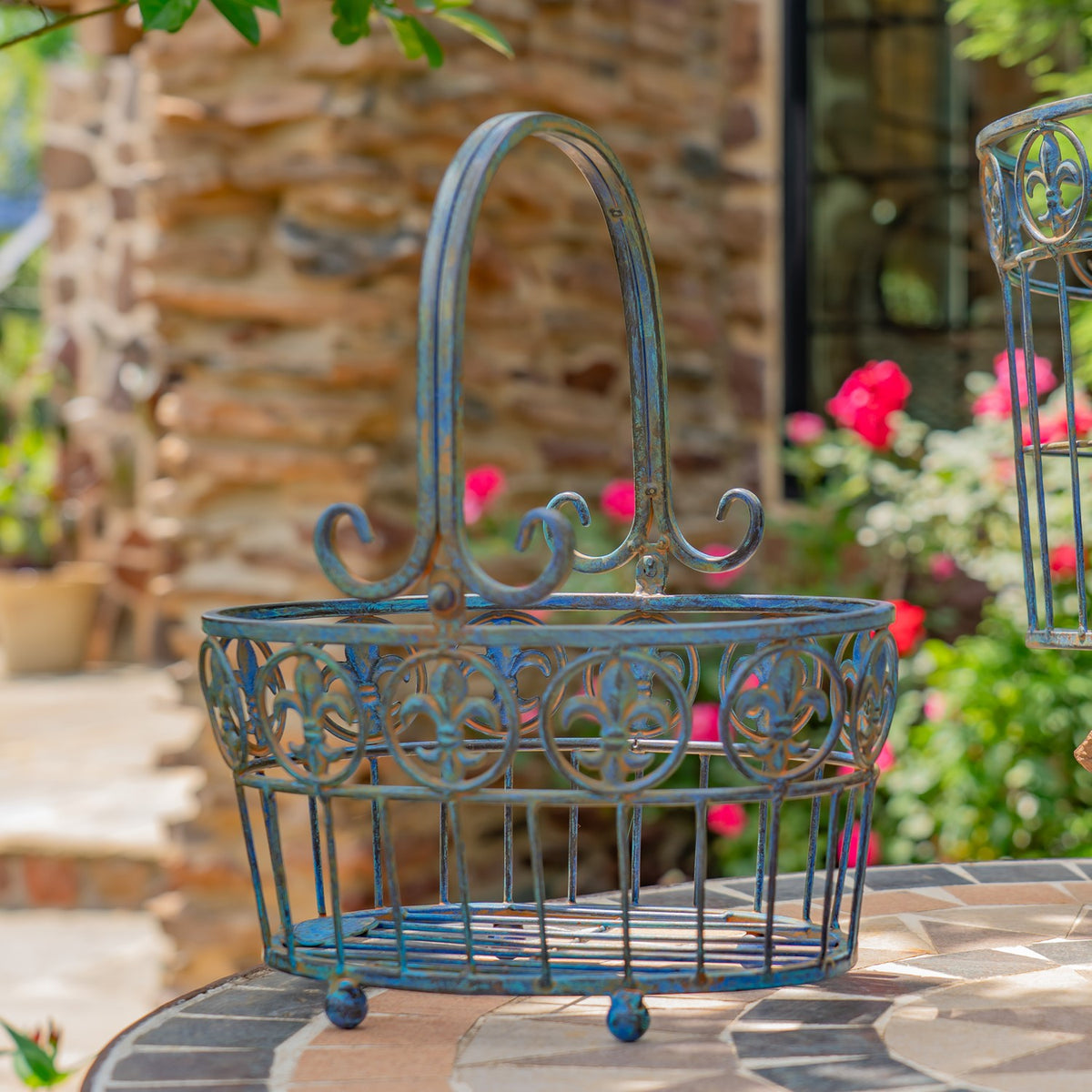 Close view of an iron wire basket showing its curled handle and decorative circular rim.