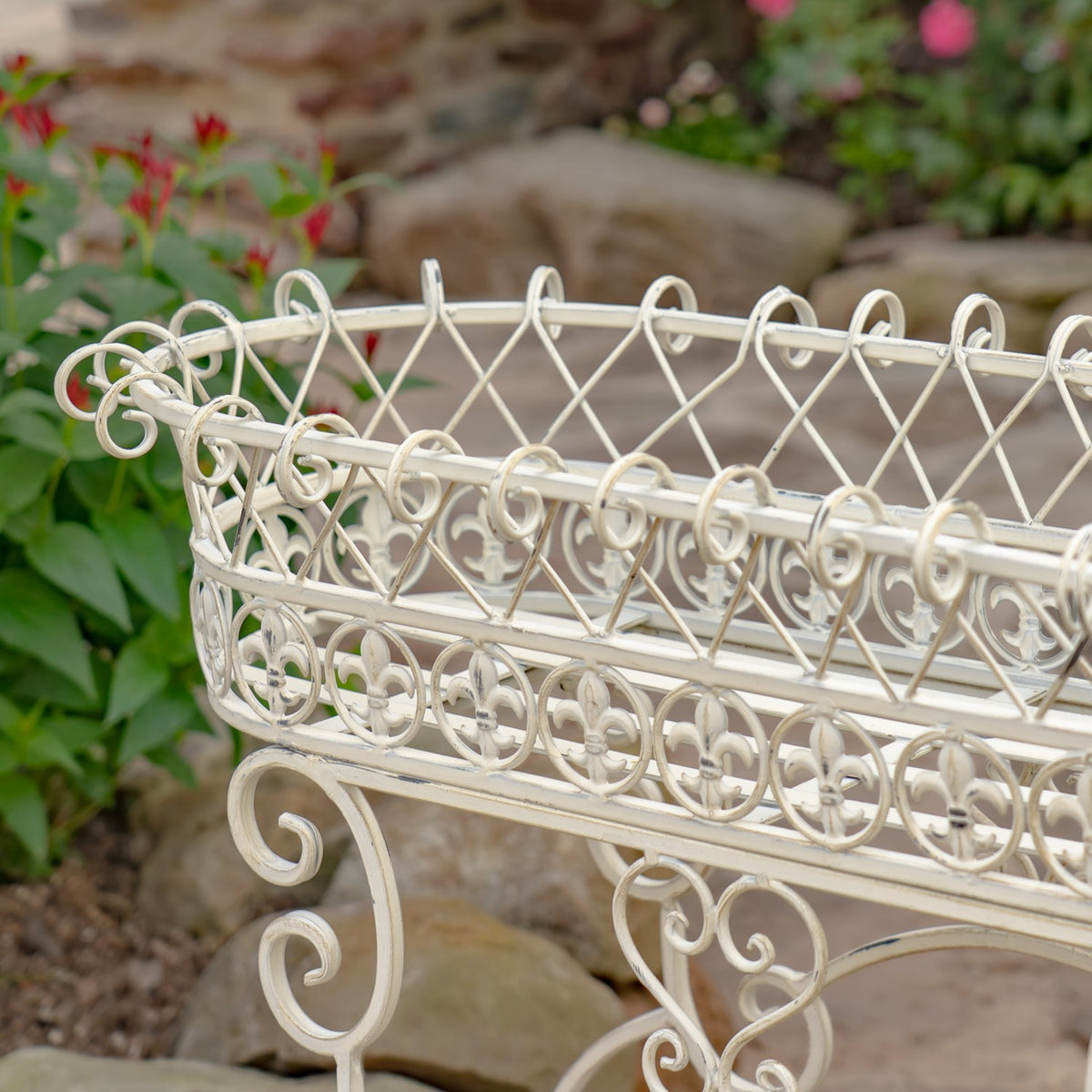Close-up of an ivory oval basket with looping wirework and scroll embellishments.