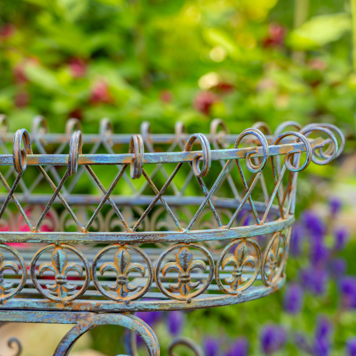 Close-up of the oval basket’s iron rim, with looped edging, crisscross bars and circular floral motifs.