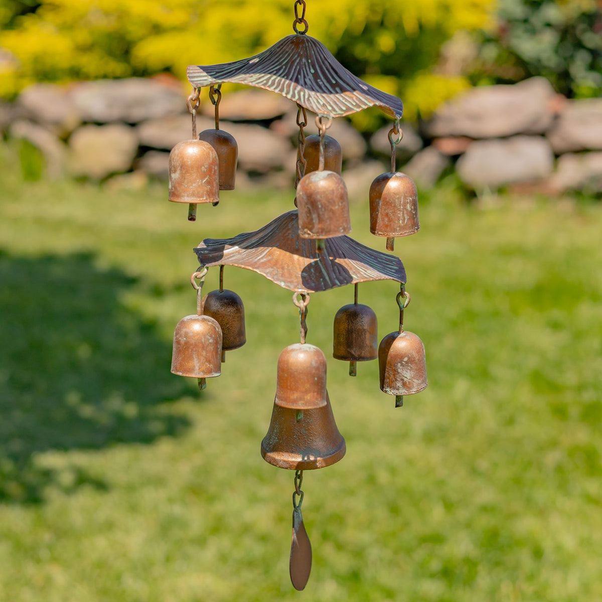 Cluster of copper-toned wind chimes hanging beneath the birdfeeder