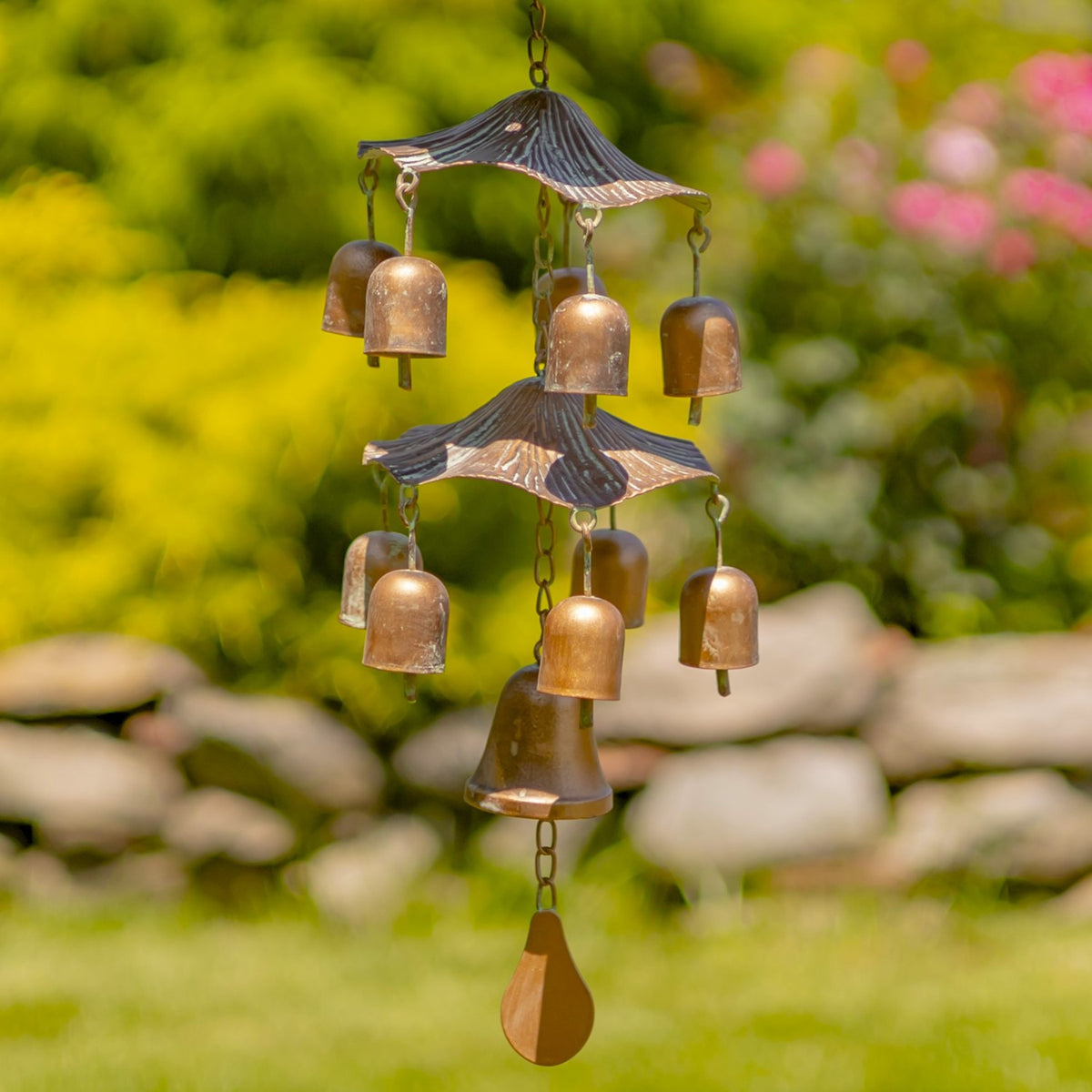 Two small pagoda-shaped roofs suspend rows of bronze-toned bells above a teardrop-shaped clapper.