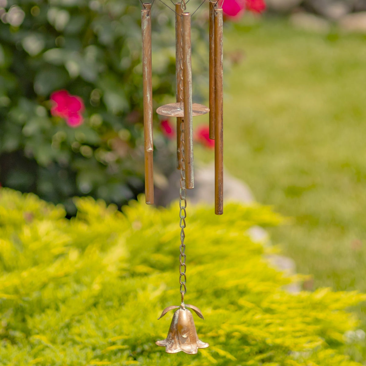 Three hanging metal tubes and a small flower-shaped bell beneath the angel wind chime.
