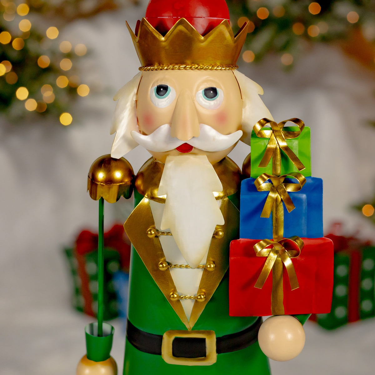 A green-coated nutcracker holds a stack of three brightly wrapped gifts.