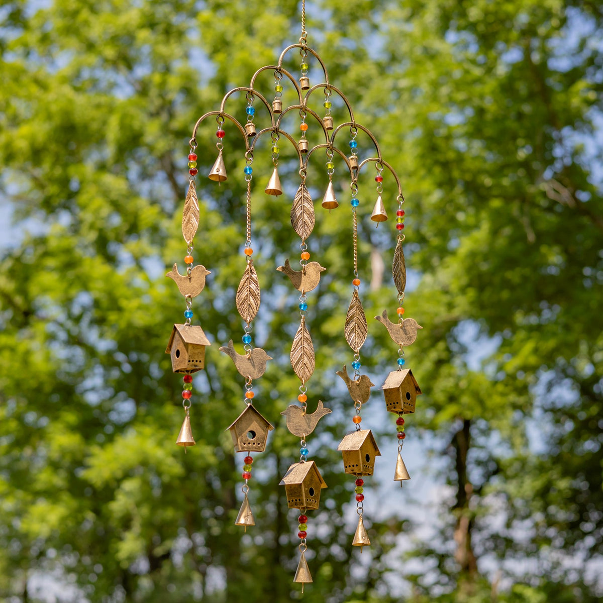 Gold-tone wind chime shown at an angle, with dangling birds, leaves, bells and birdhouses.