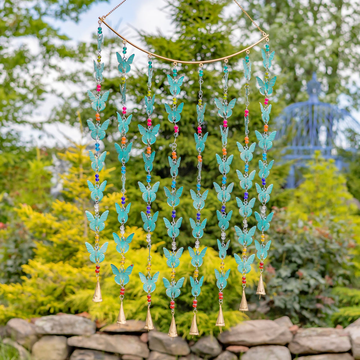 Turquoise butterfly ornaments hang in rows from a chime with colorful beads and gold-toned bells.