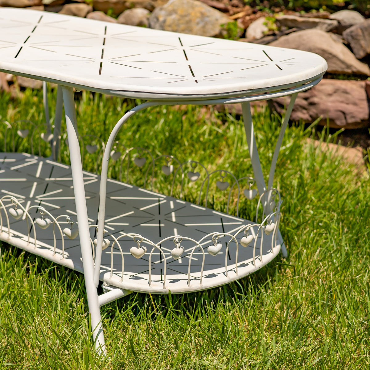 Antique white oval garden table shown from an angled side view