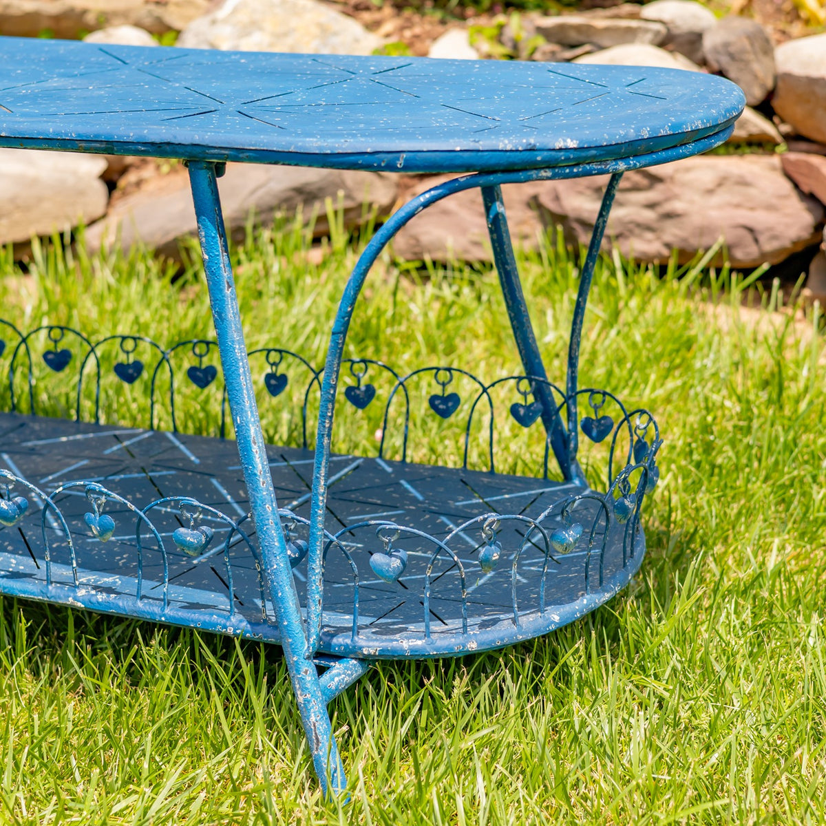 Angled view of the blue table’s curved legs and heart-patterned shelf railing.
