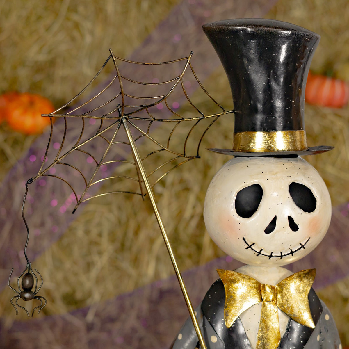 Close-up of the skeleton boy's face, top hat, and spiderweb umbrella