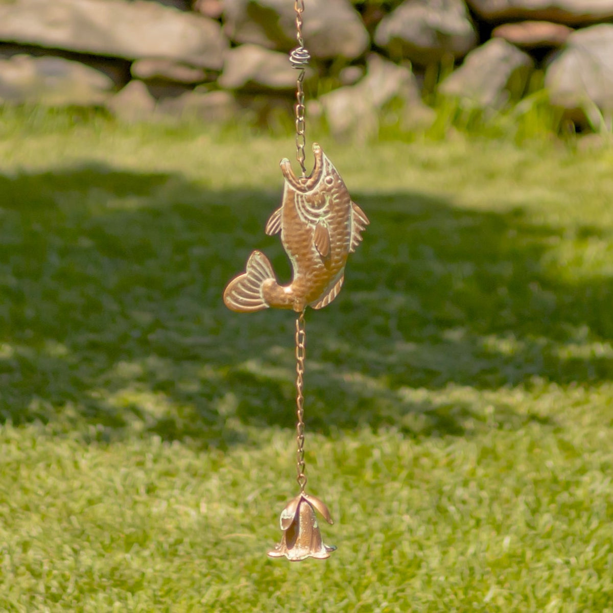 A single fish ornament and the small bell-shaped piece at the end of the chain.