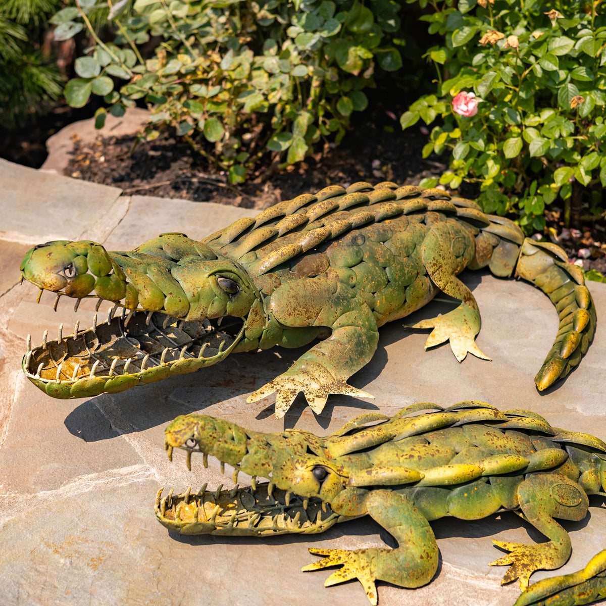 A larger alligator decoration sits behind a smaller one, showing their textured backs and open jaws.