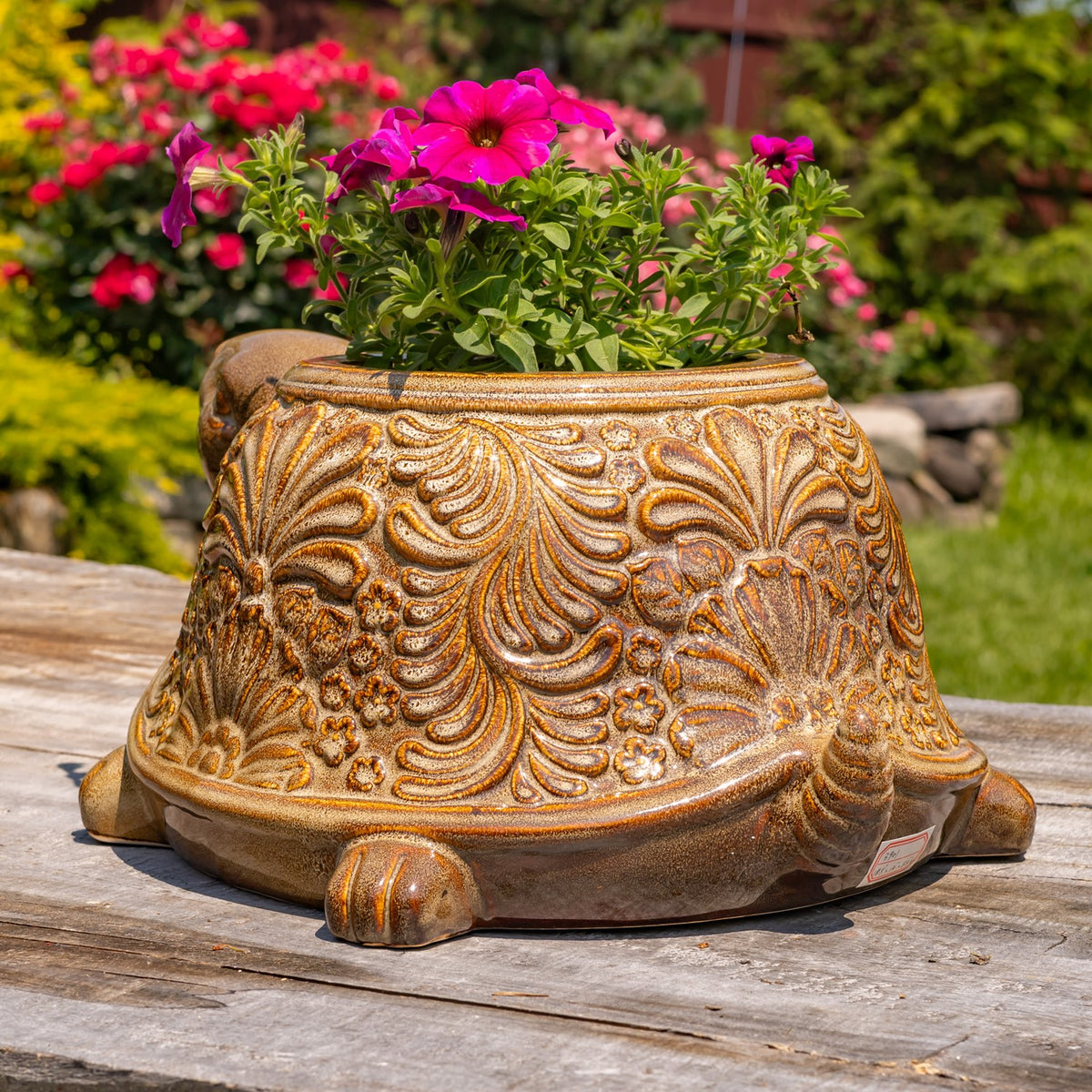 Back of the flower-filled turtle planter, showing the embossed shell and small tail.