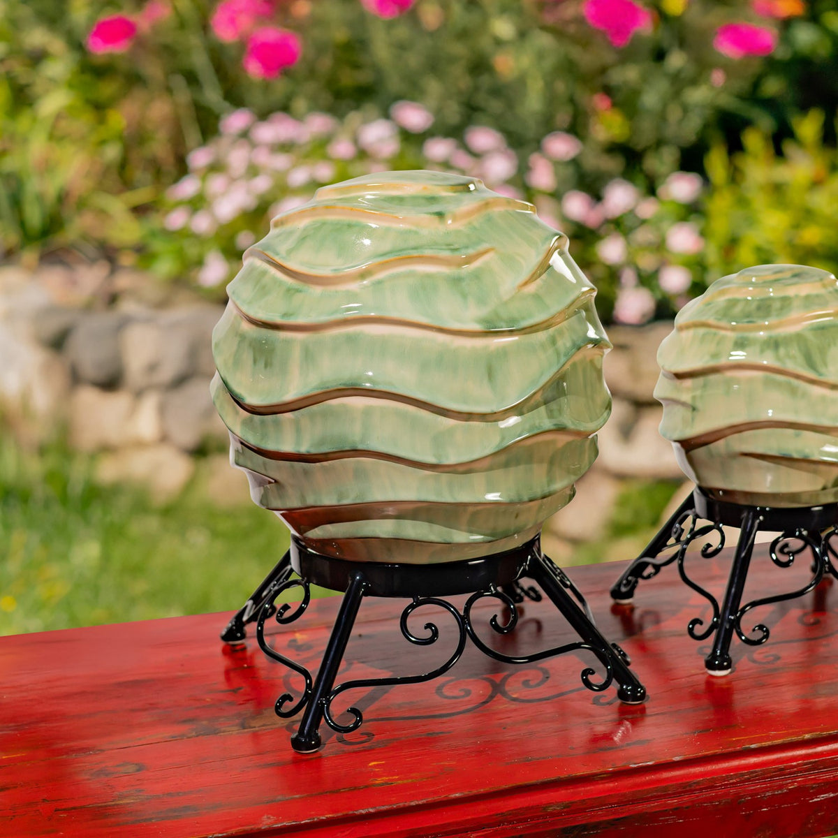 A large ribbed pale green globe on a curled metal stand, with part of another globe at the right.