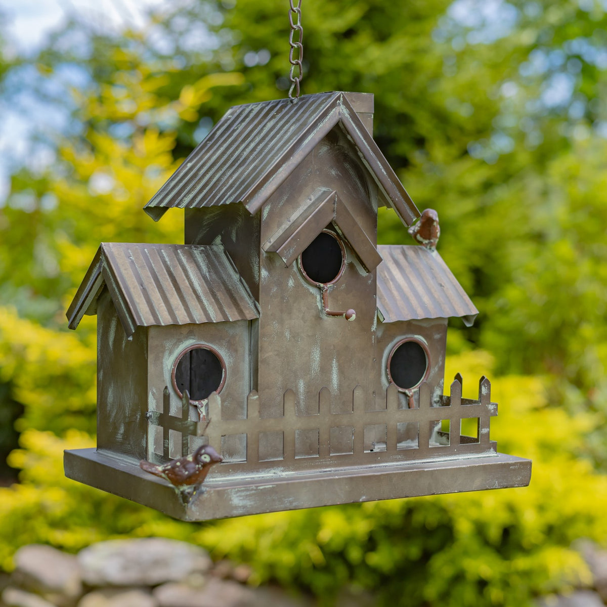 Hanging birdhouse with three round openings, two smaller side roofs, and a picket fence along the platform.