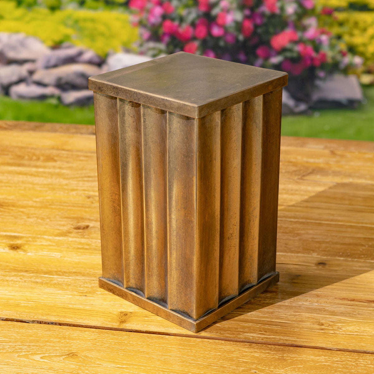 Close view of one gold-toned pillar showing its flat square top, fluted sides, and raised base.