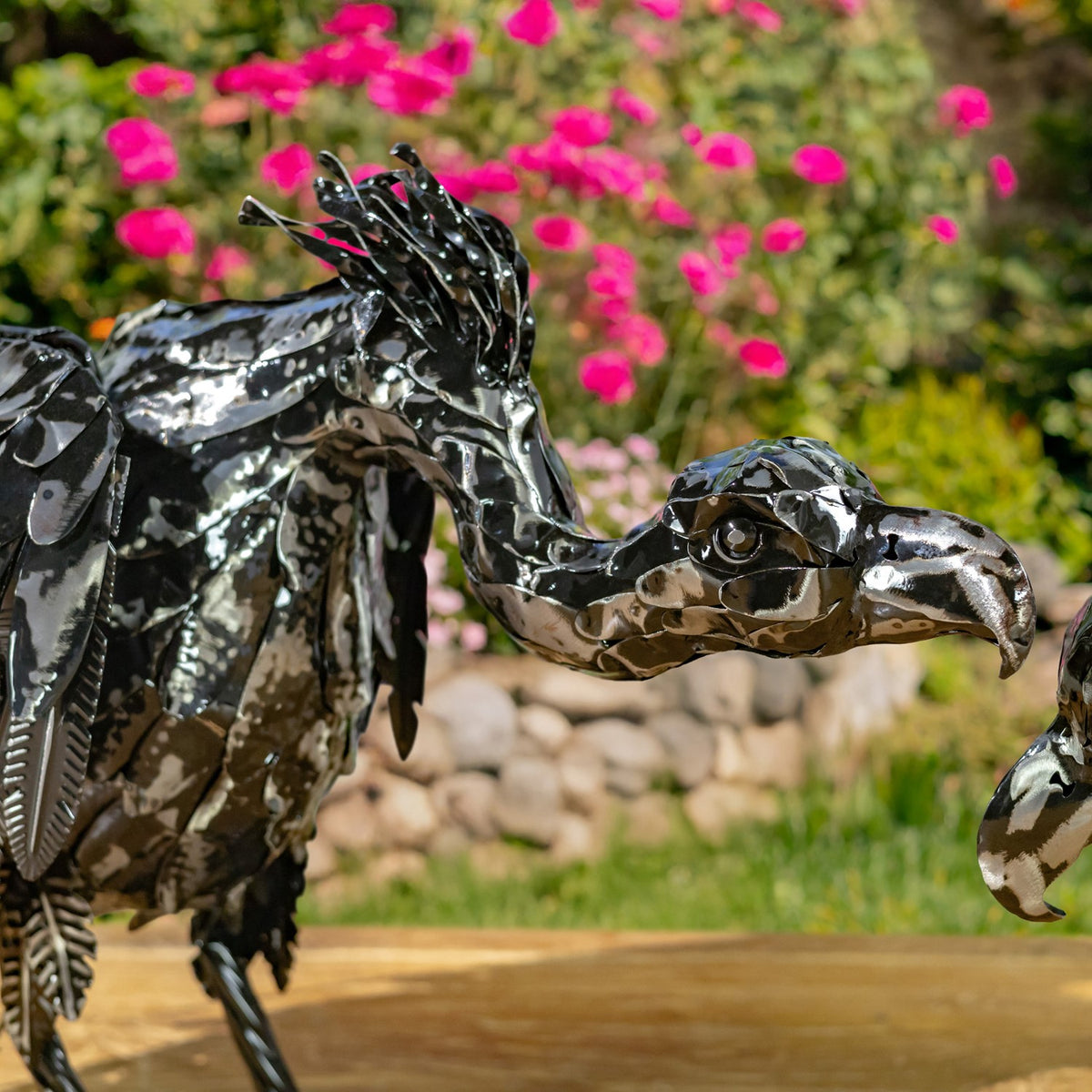 Detailed view of a metallic black vulture figurine's head and layered feathers