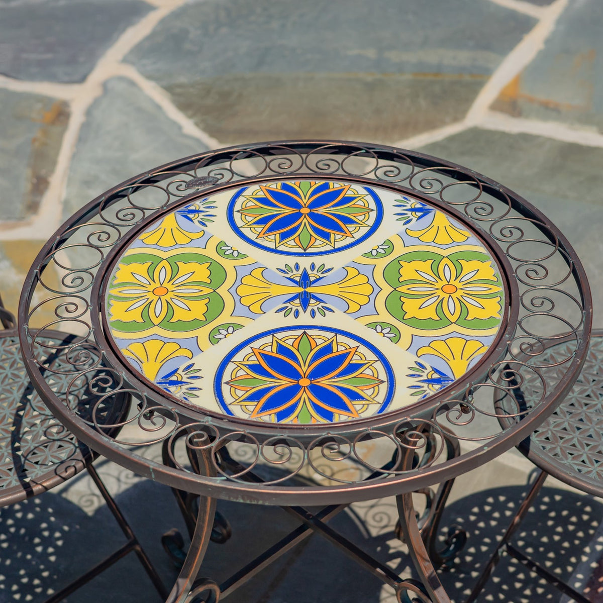 Close view of the table’s colorful blue, yellow and green mosaic surrounded by curling metalwork.