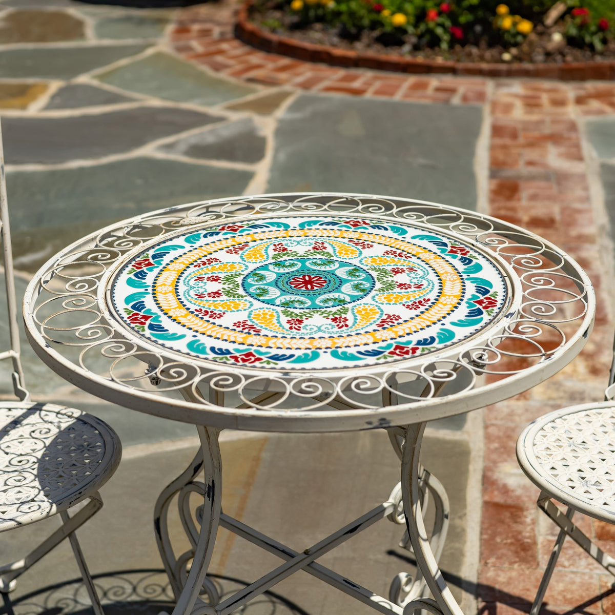 Round tabletop with a colorful circular mosaic pattern and scrollwork metal border.