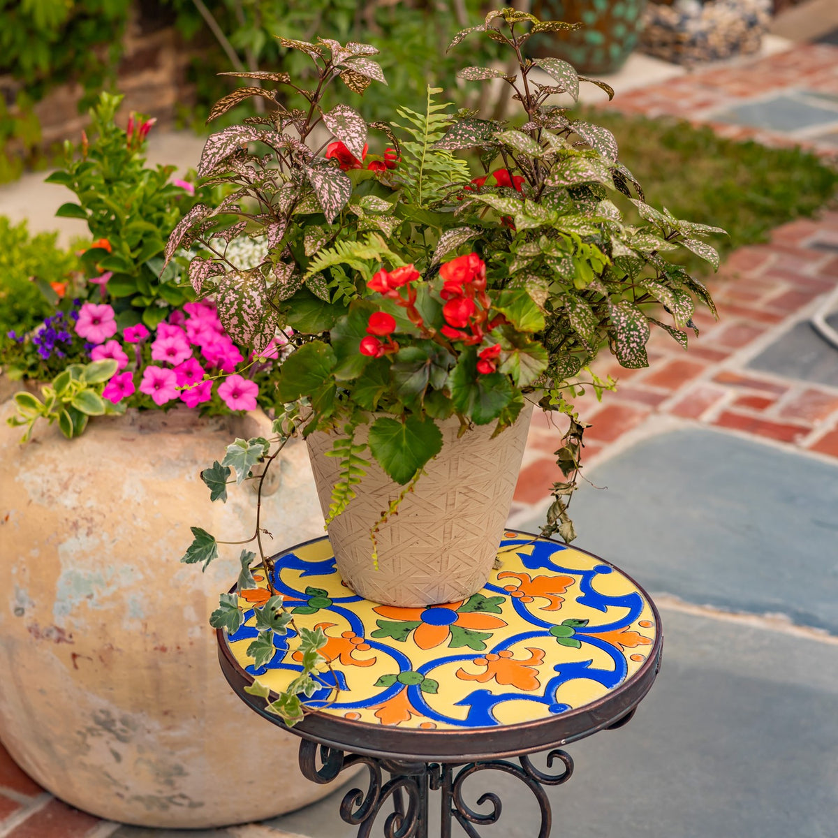 A leafy potted plant sits on the stand's bright blue, yellow, and orange patterned top.
