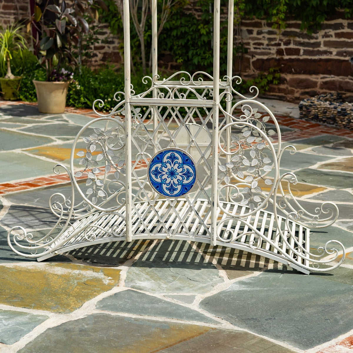 Front view of the bridge’s latticework, curled side rails and round blue floral mosaic.