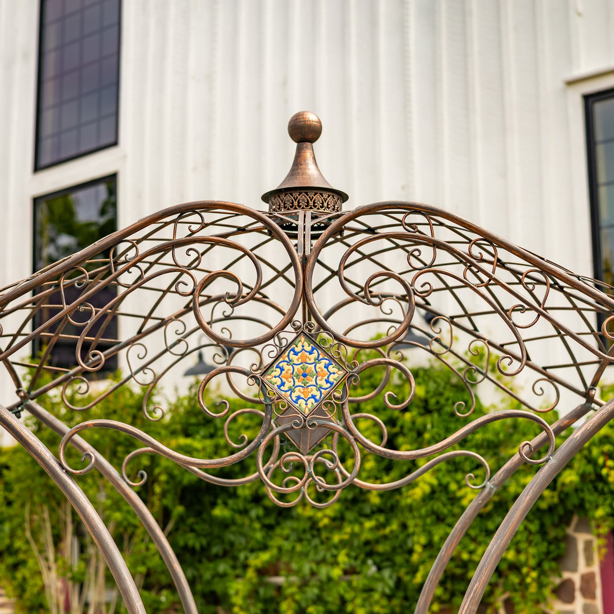 Curving scrollwork and a small patterned mosaic beneath the bridge’s pointed finial.
