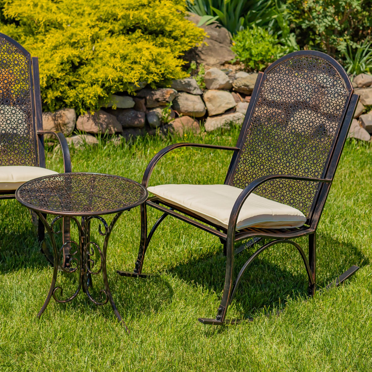 One rocking chair and the round table are shown close up, with part of the second chair at the edge.