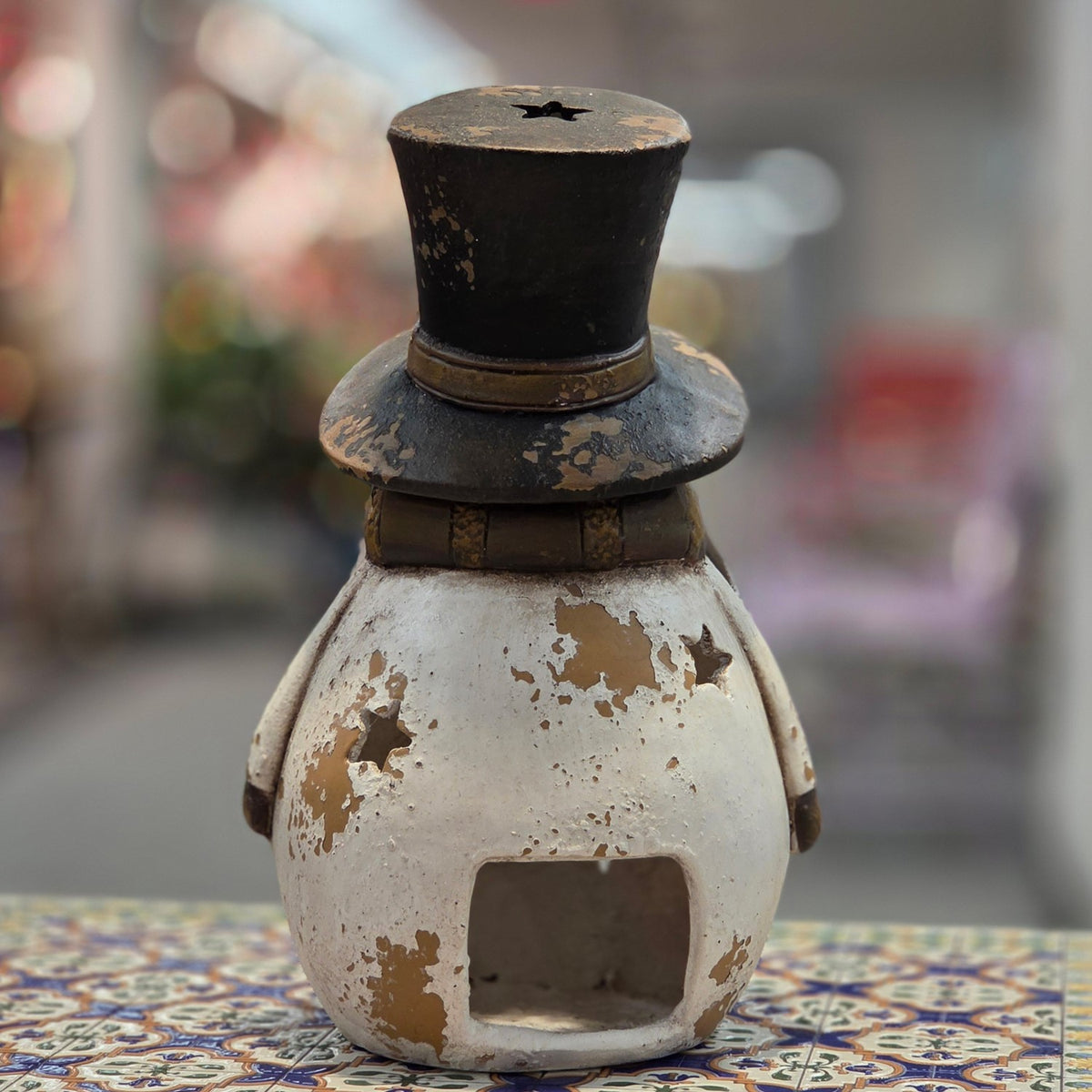 Back view of distressed snowman candleholder showing the hollow opening