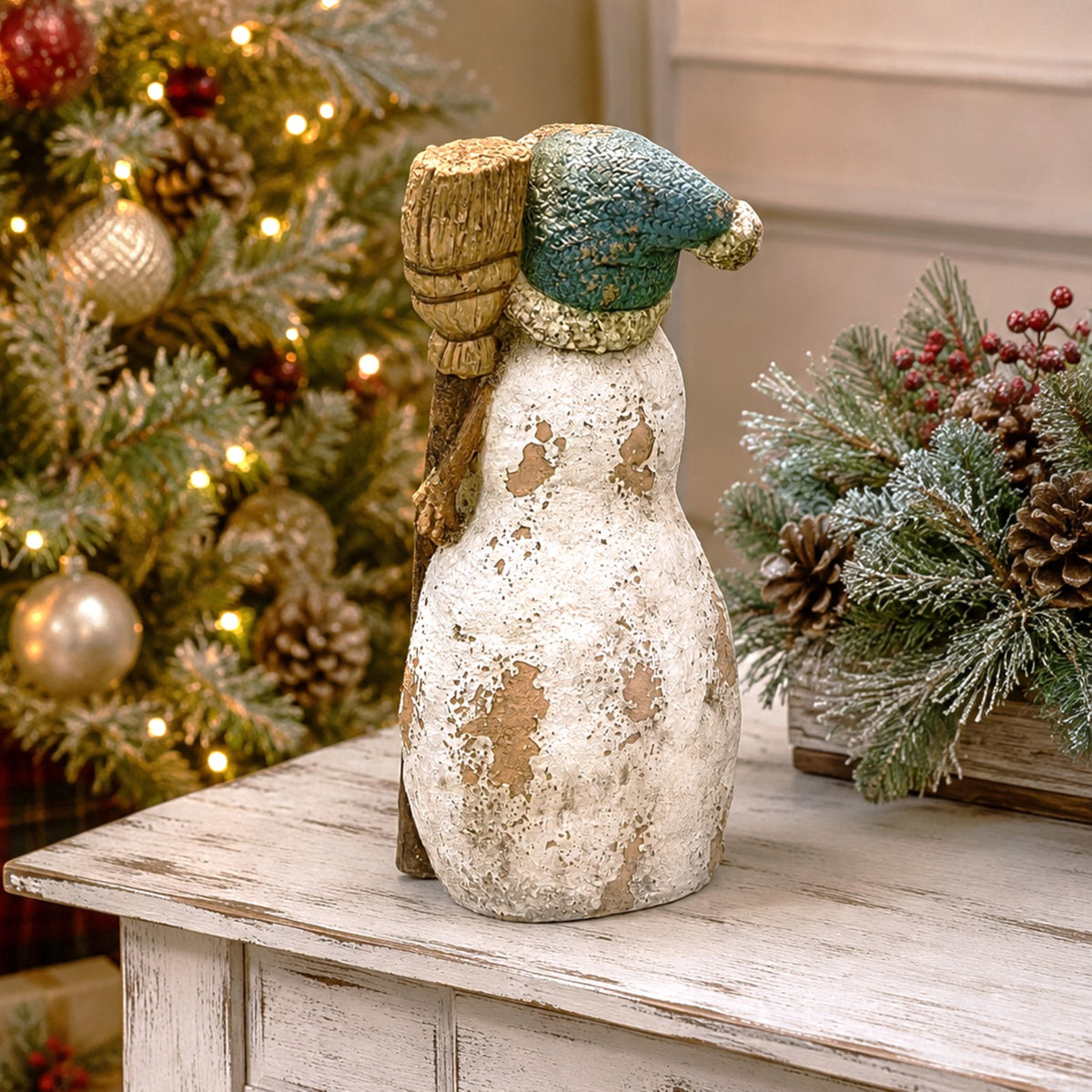 Rear view of the snowman figurine showing its textured finish and broom