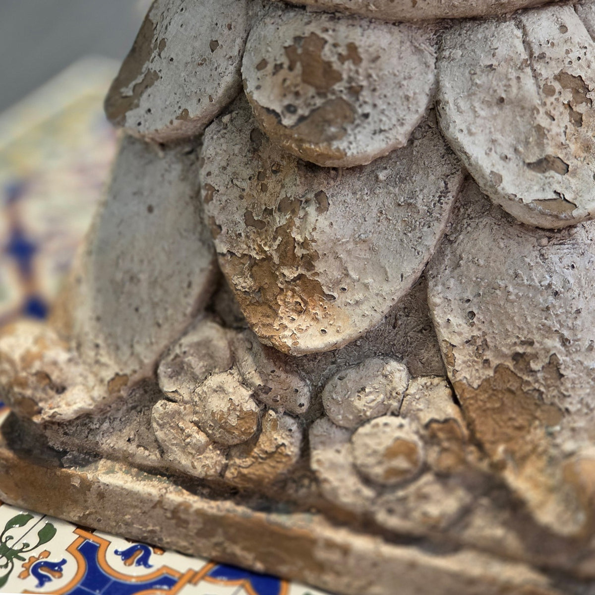 Close-up of textured leaf and floral carvings on the pedestal base