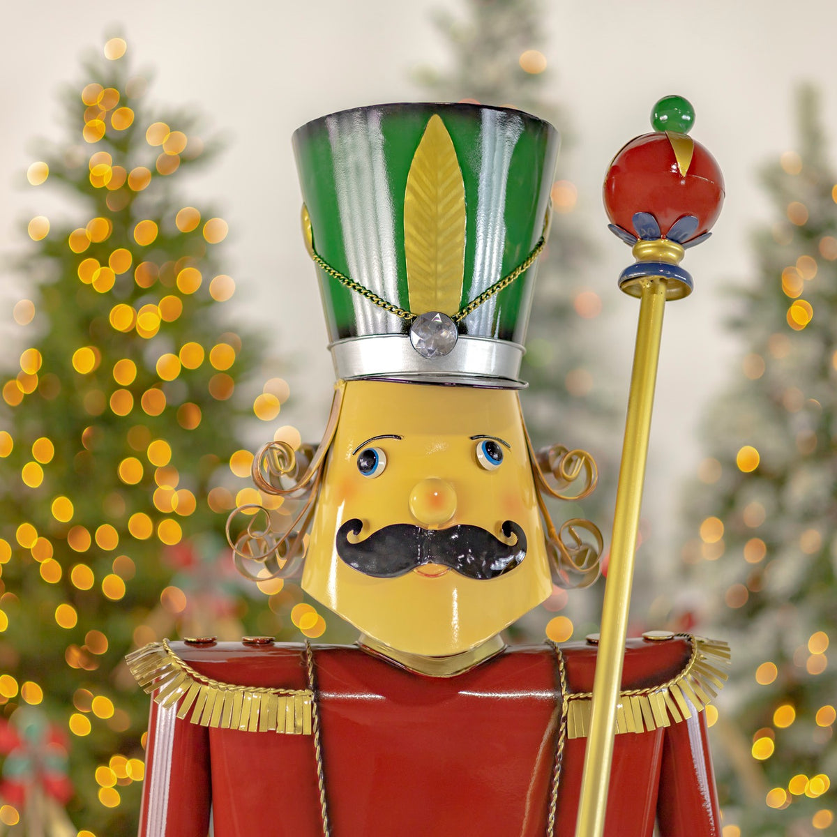 Close-up of the nutcracker's face, green hat and baton with blurred holiday lights
