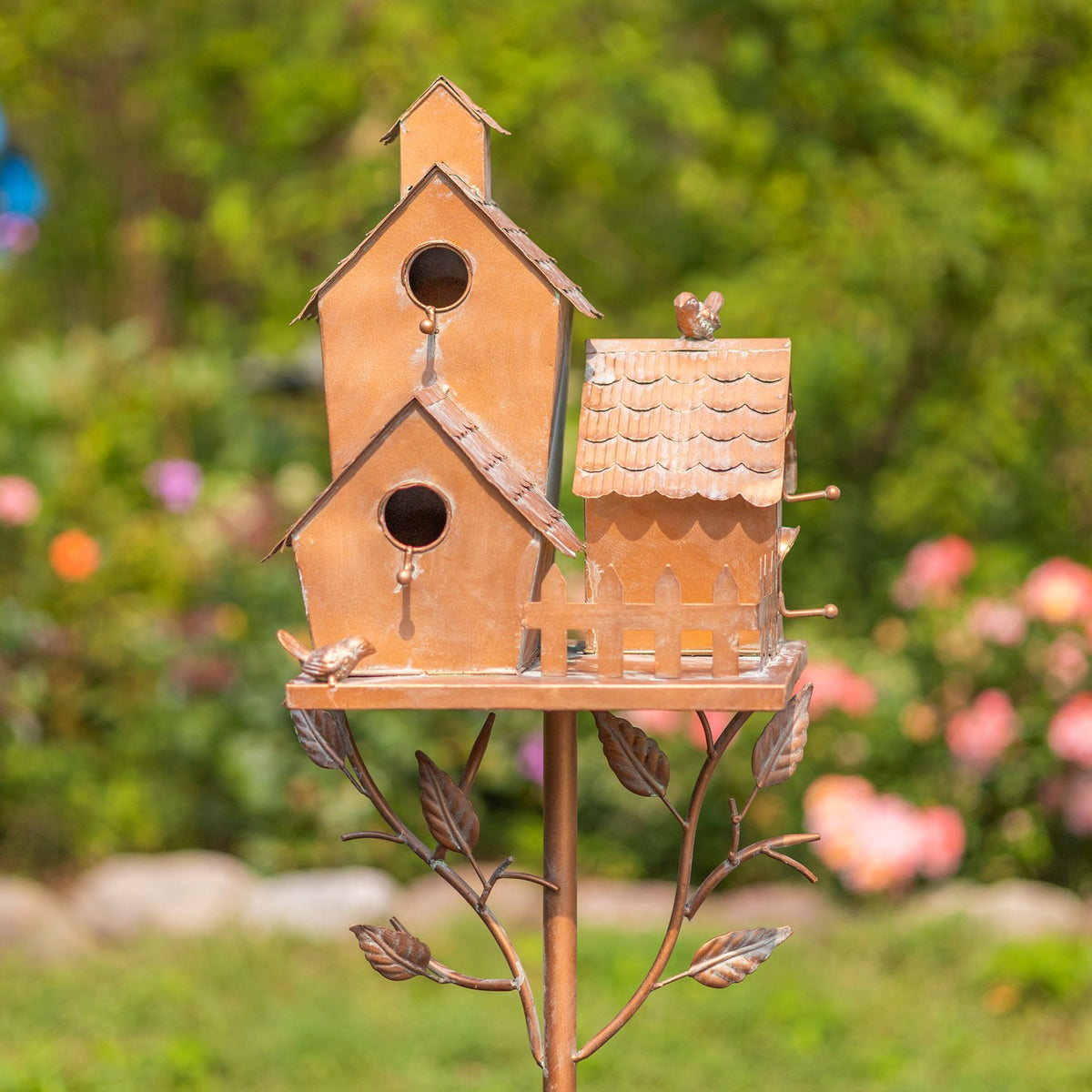 Birdhouse cluster viewed straight on, showing the roofs, fence and decorative birds