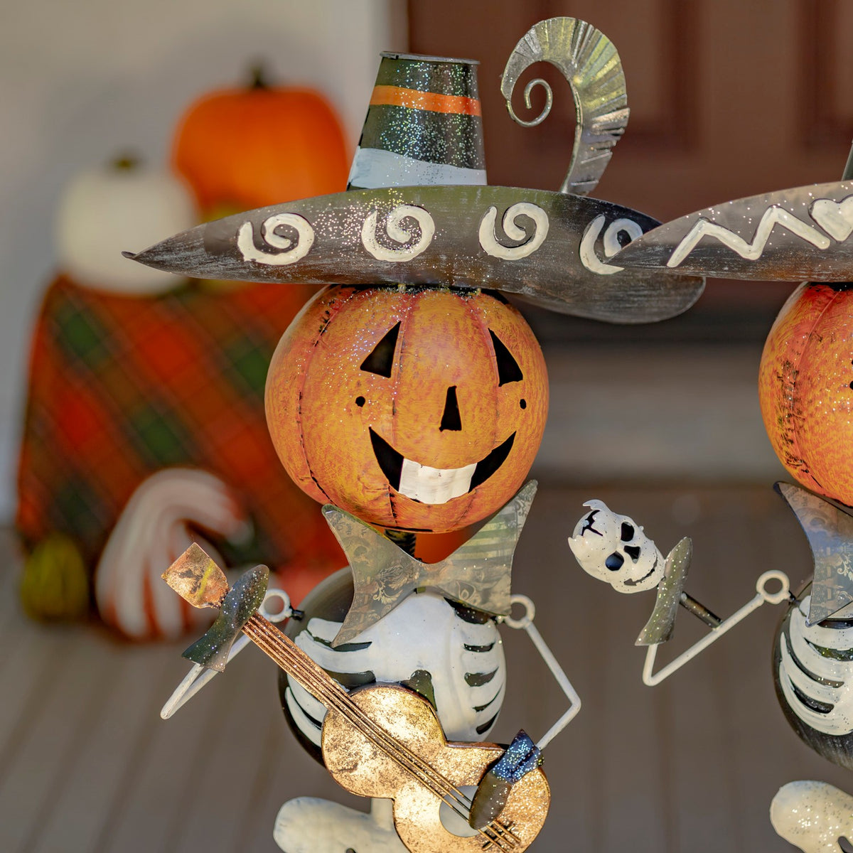 Close-up of a guitar-playing skeleton figurine with a pumpkin head and sombrero