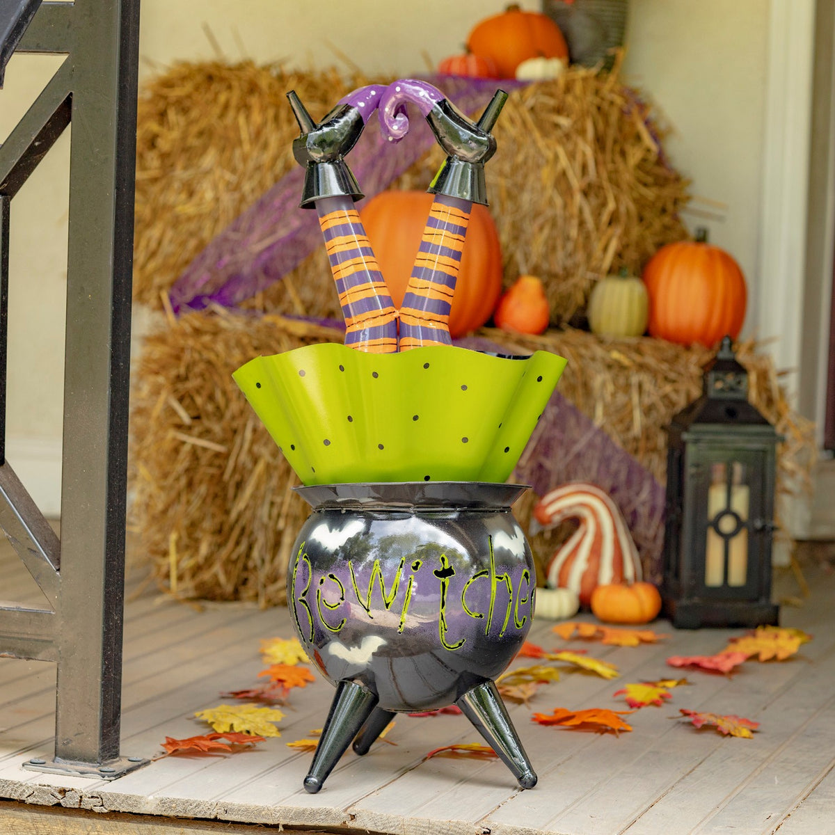 Full cauldron decoration on a fall porch with pumpkins and lanterns