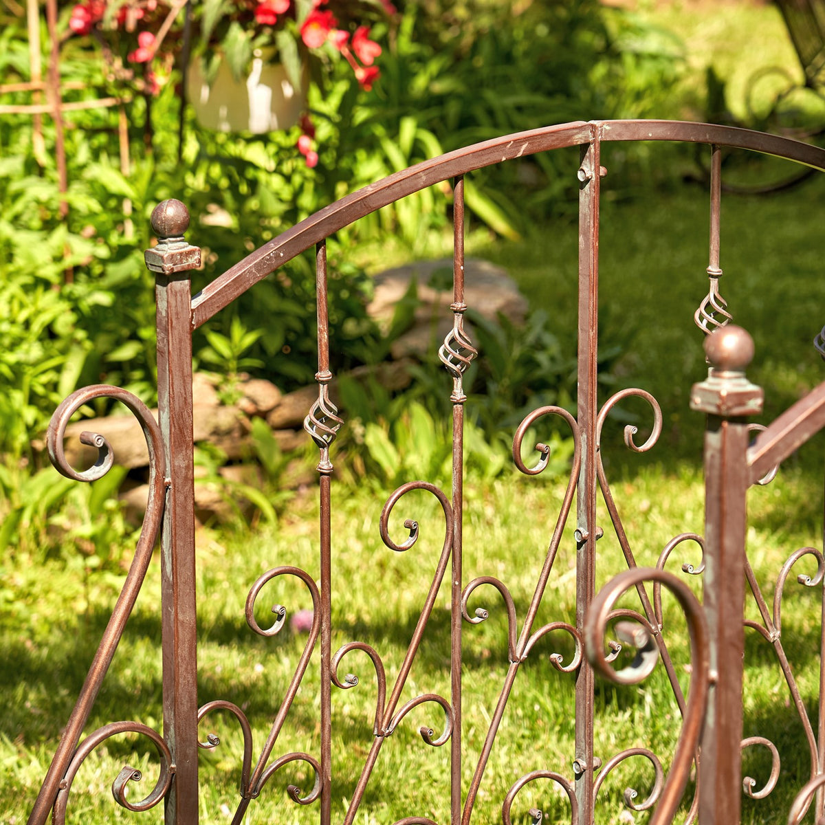 Close-up of the bridge railing with curled metal ornaments, twisted spindles and rounded finials.