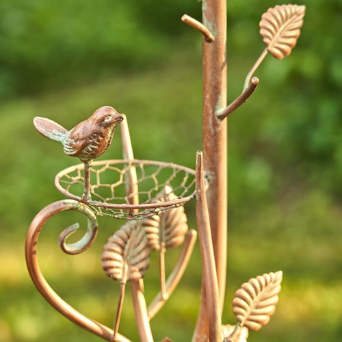 Close view of a bird ornament and leaf details on the copper garden stake
