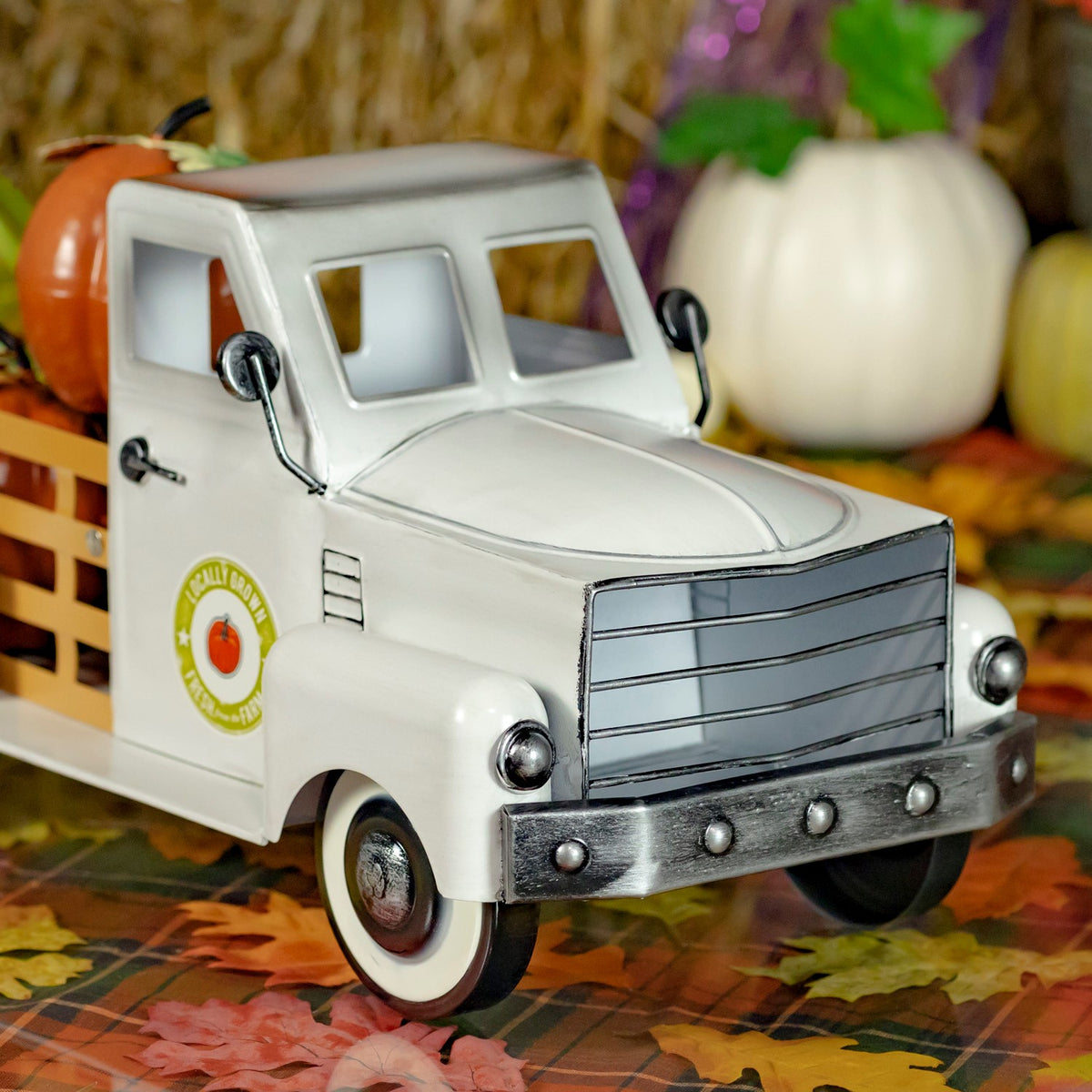 Close front angle showing the truck’s grille, bumper, headlights, and whitewall tires.