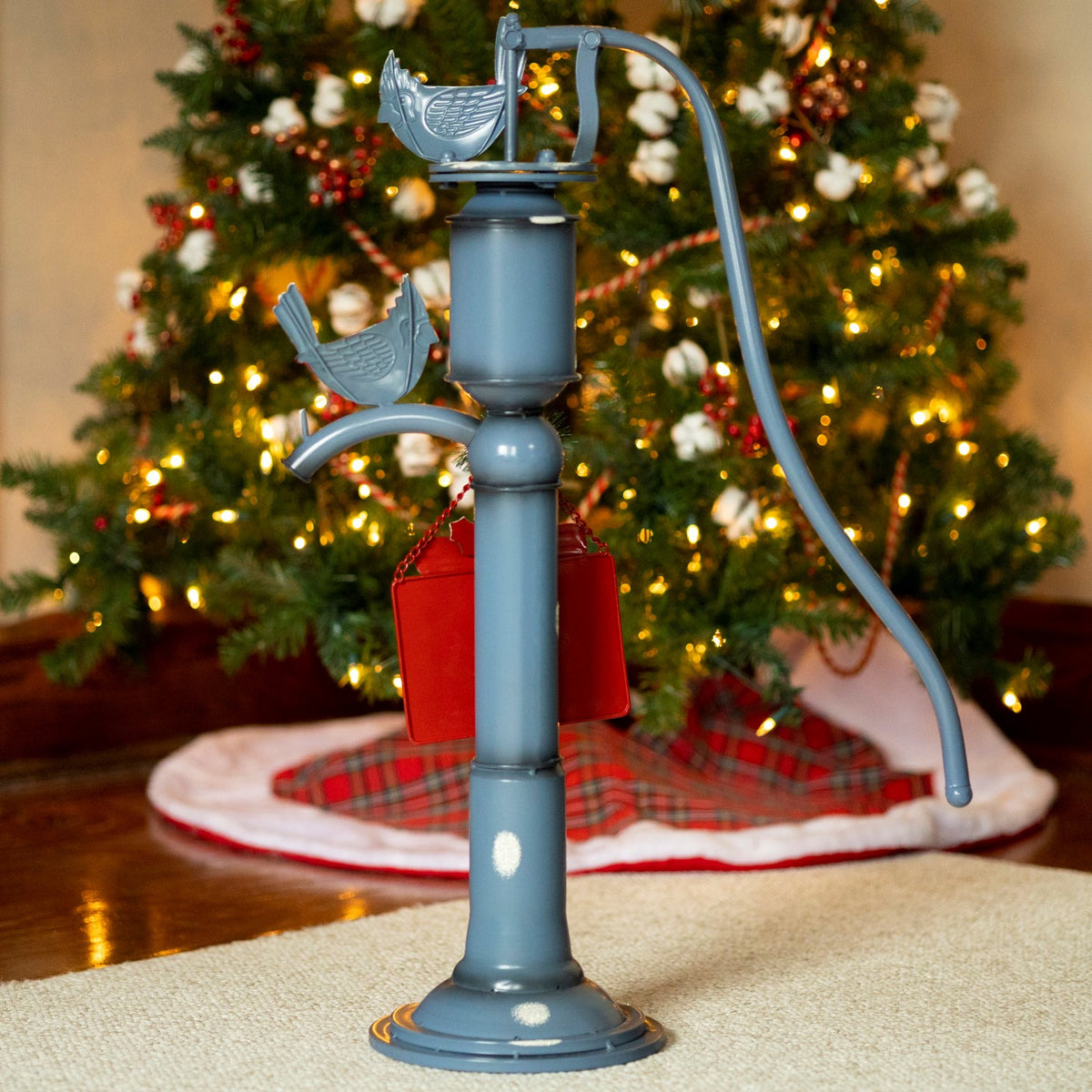 Back of the blue pump decoration, with gray bird figures and the plain red back of its hanging sign.