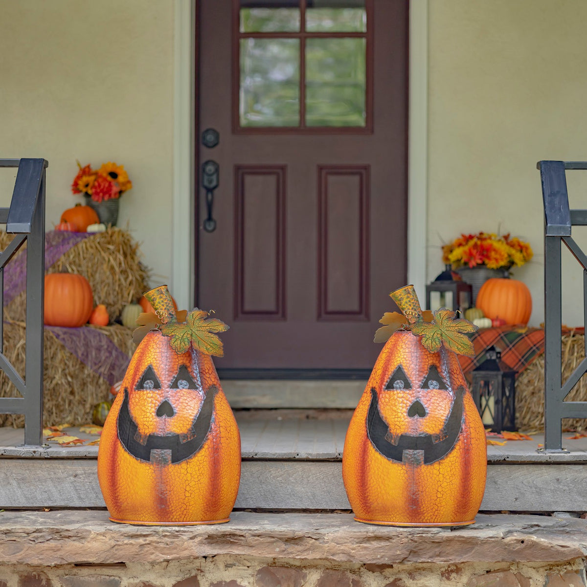 Two matching orange jack-o'-lantern decorations on a front porch