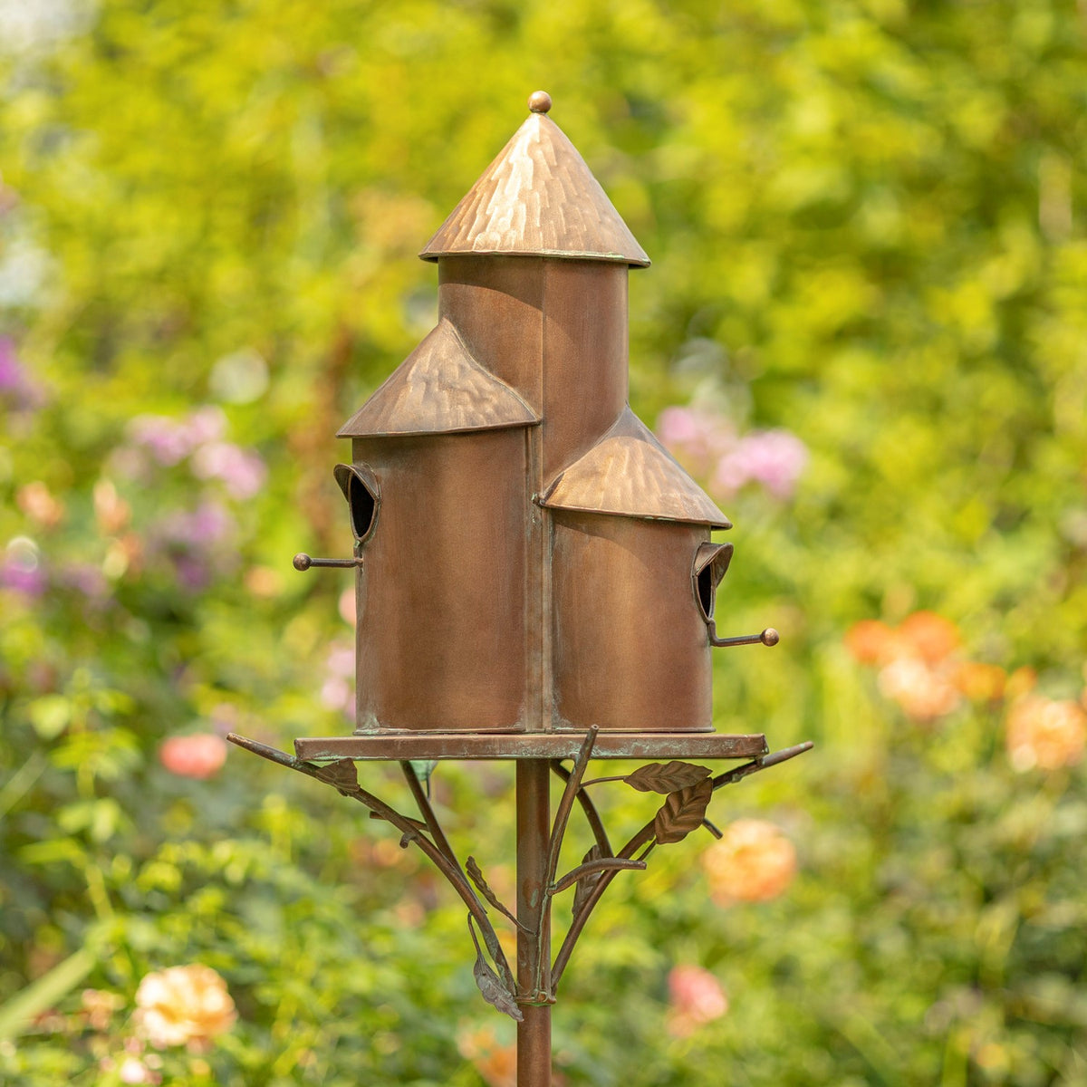 Antique copper triple birdhouse stake viewed from another garden angle