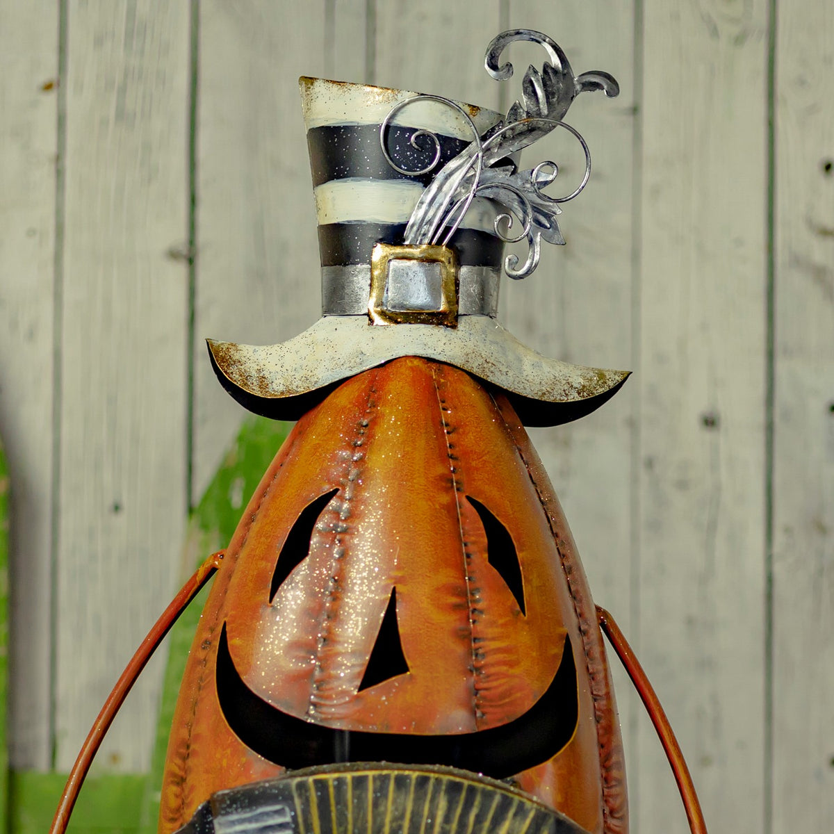 Close-up of the pumpkin figurine's striped hat and glitter-accented face