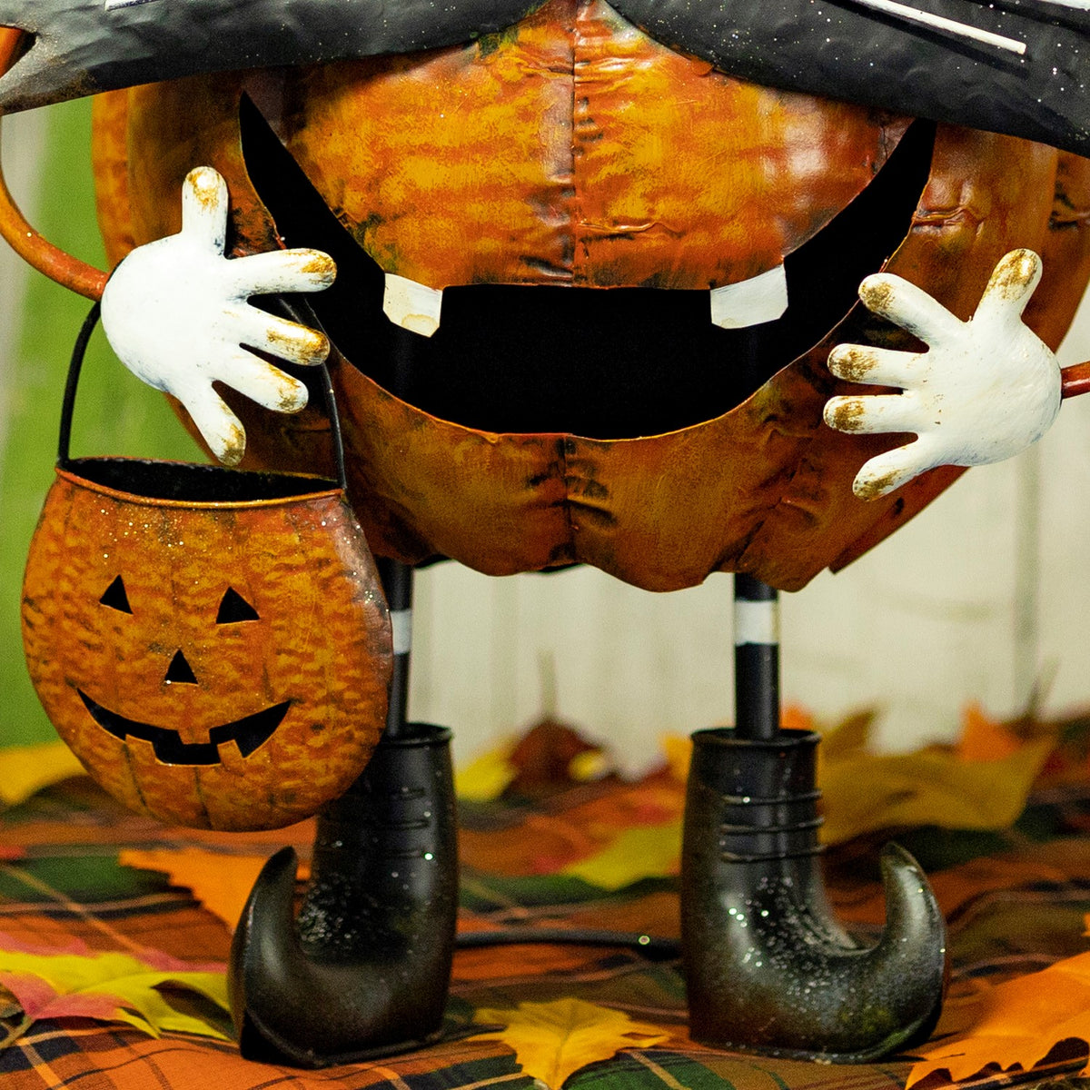 Close-up of the orange pumpkin body, white hands and black boots