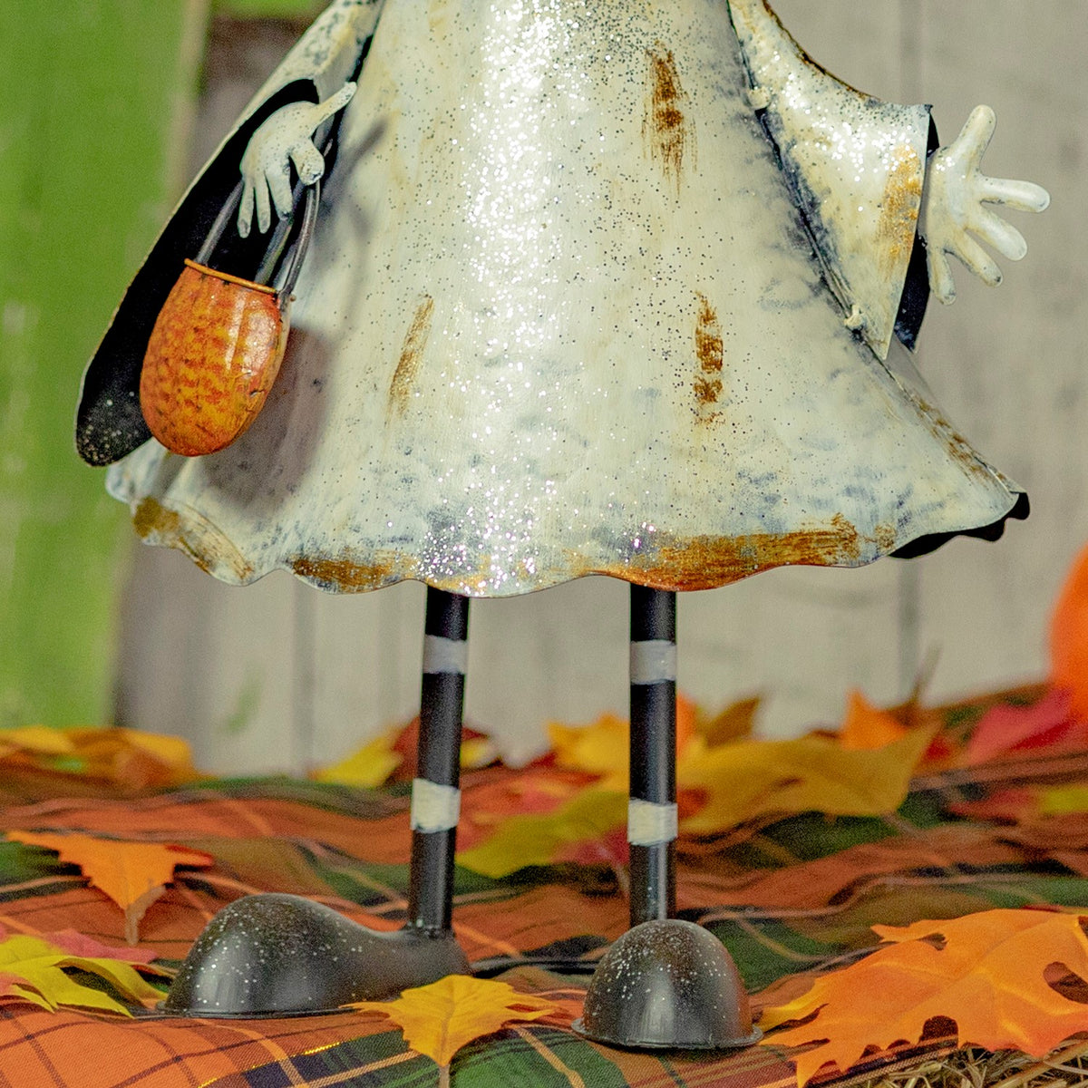 Close view of the distressed white dress, striped legs, and small orange bag