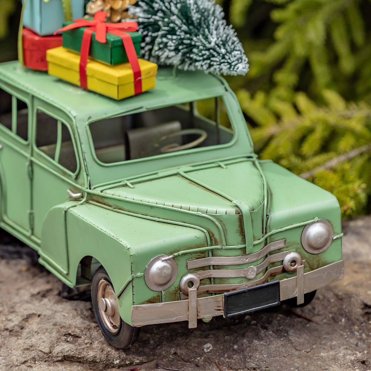 Close front view of the distressed light green car and its metal grille